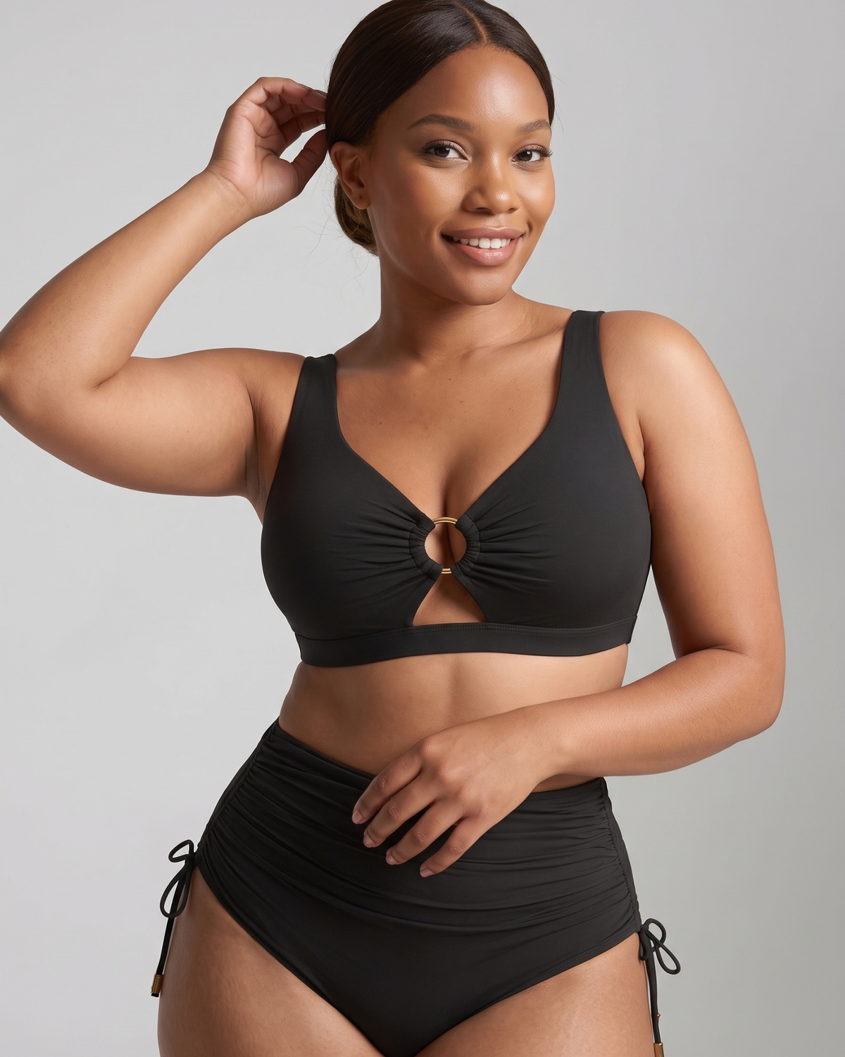 Women wearing black bikini against grey background