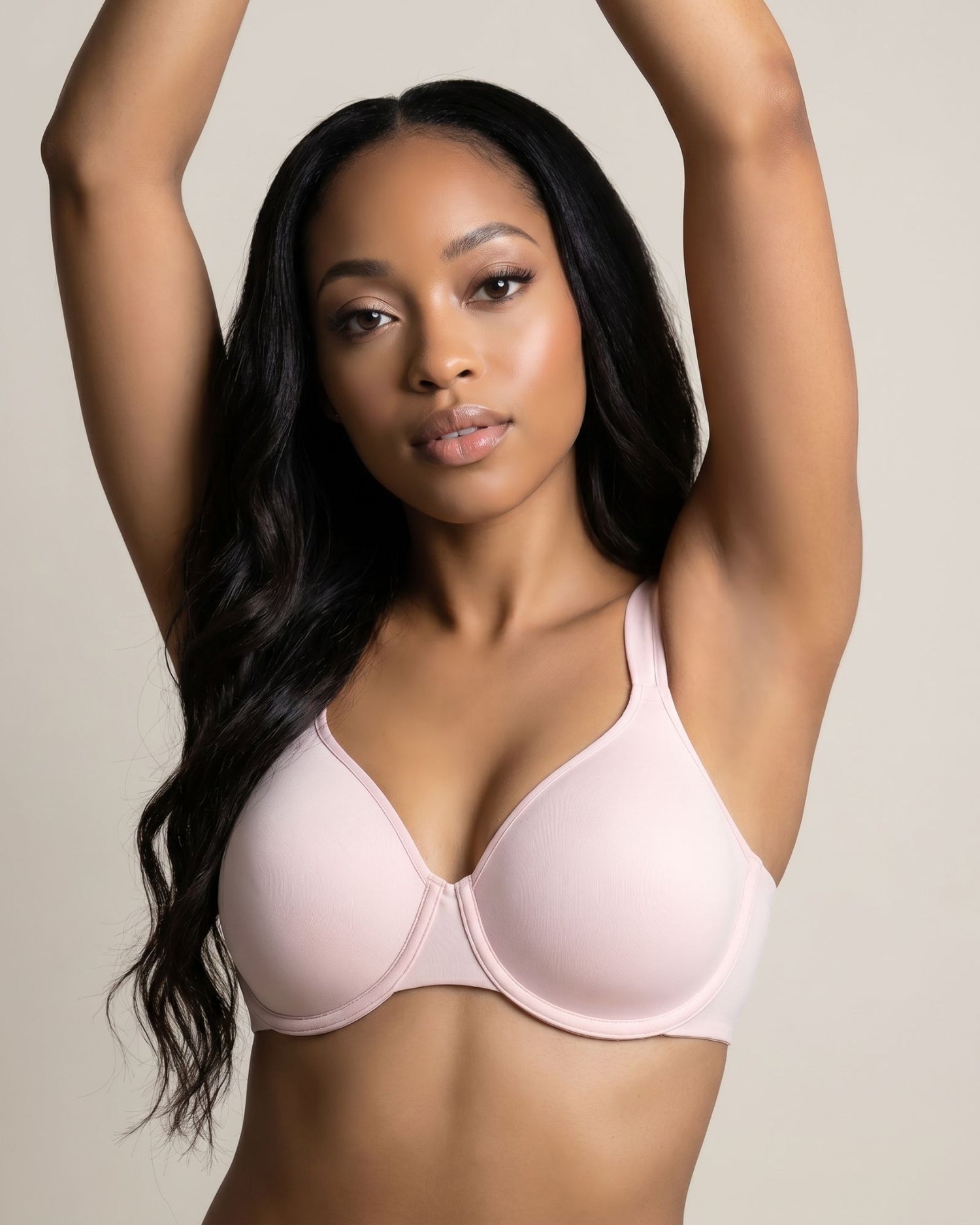 Woman wearing a light pink bra against a neutral background